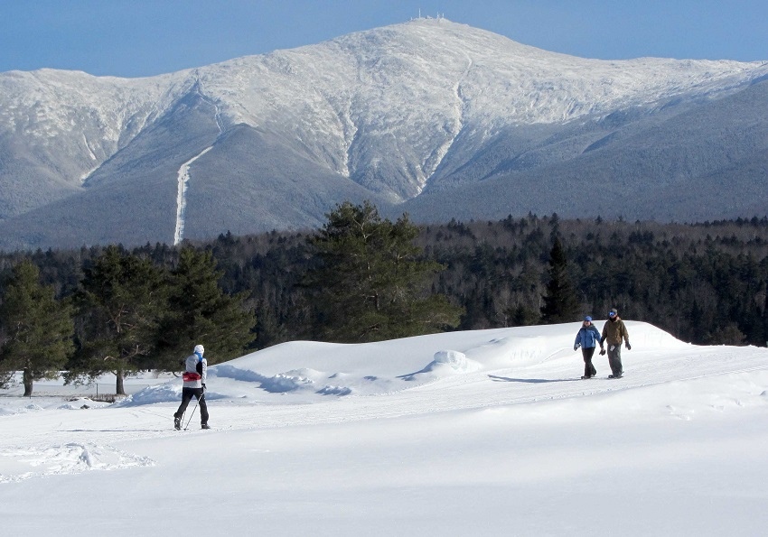 Cross Country skiing and snowshoers with Mount Washington and cog railway in the background