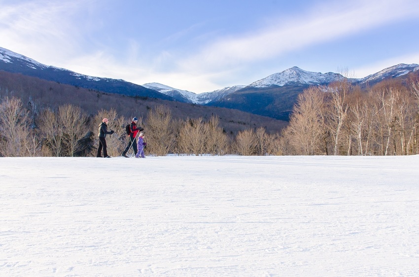 Family skiing at Great Glen Trails mountains in the background