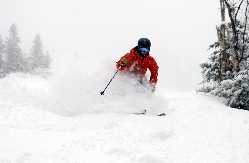 Skier in powder red jacket