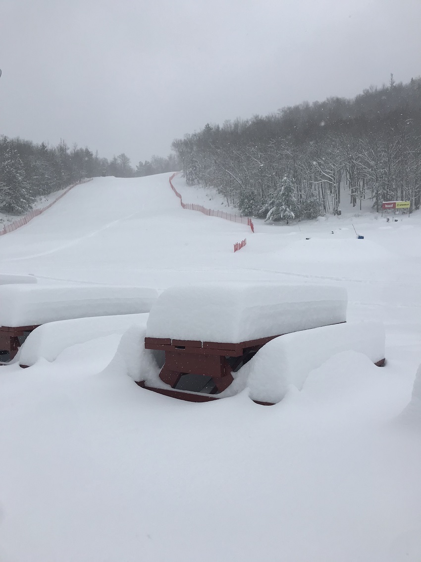 Snow piling up on picnic tables