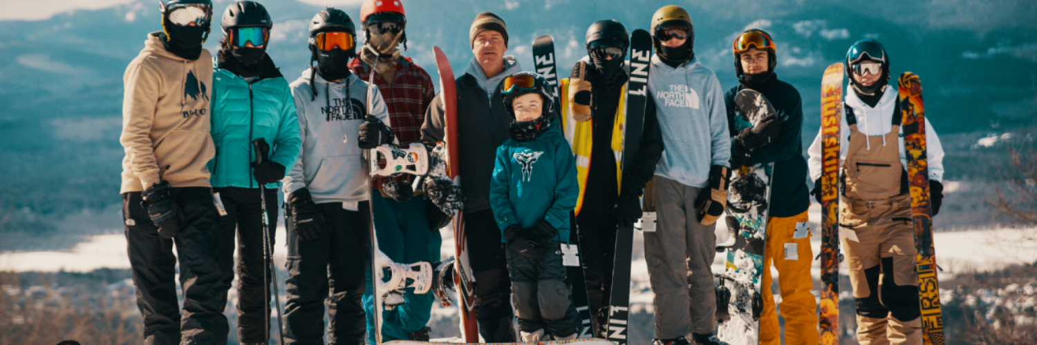 Group of skiers and snowboarders mountains in background