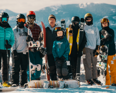 Group of skiers and snowboarders mountains in background