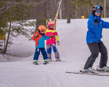 King Pine instructor with two children