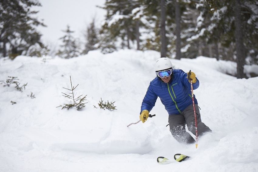 Skier making a turn blue jacket white helmet