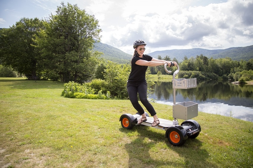 woman riding resort board past pond