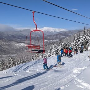 red double chair, skiers, mountain view
